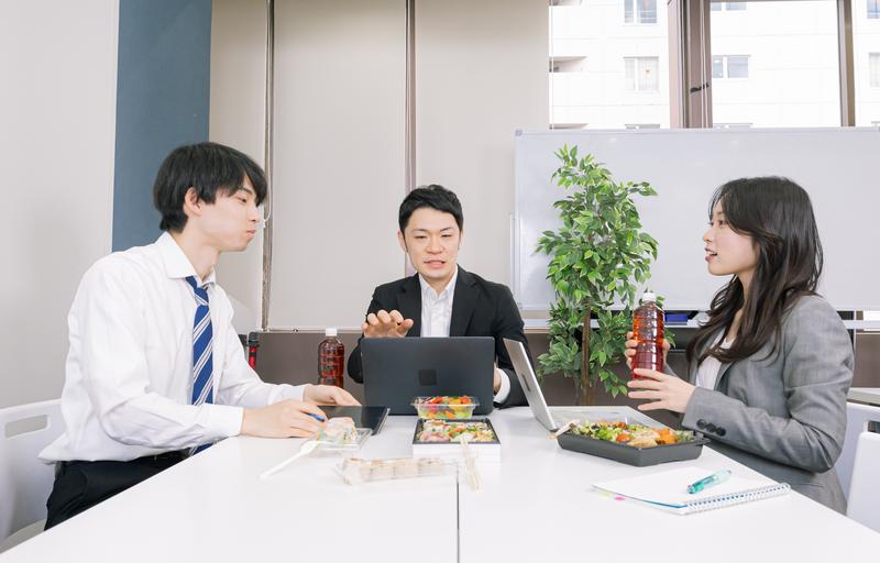 昼ごはんで会社員が3人でコミュニケーションをとっている