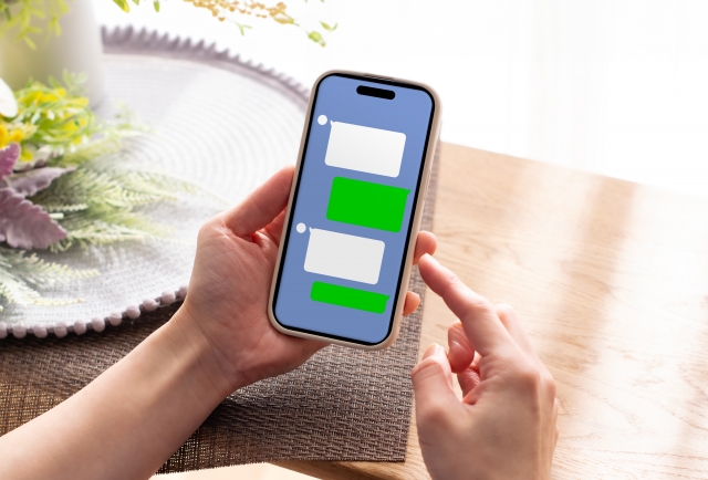 トークアプリを開いたスマホを持つ手